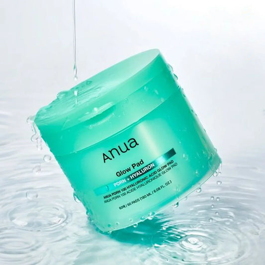 Green jar of Anua Glow Pad with water droplets on a light gray background | Deoora EGYPT